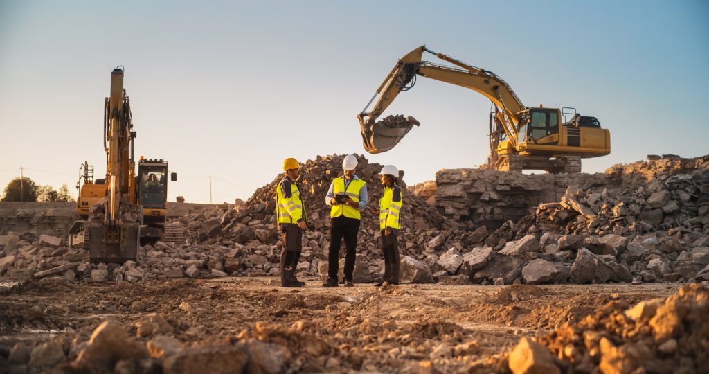 Construction workers discussing plans and collaborating on a construction site.