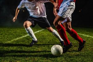 Football players in action on a pitch, representing international talent competing in the UK. Sports immigration processes help athletes secure the right visas to play professionally.