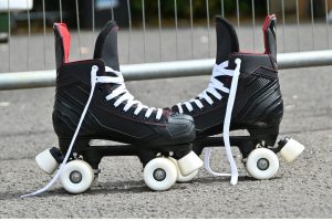 Two roller skates side by side on a smooth surface.