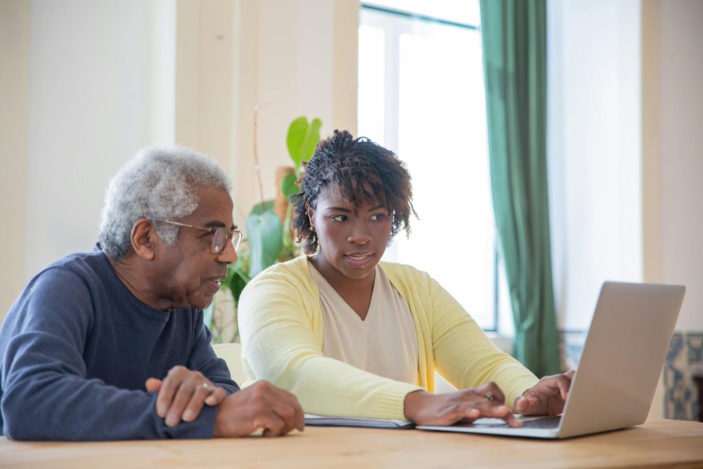 A young woman explains pension options to an elderly man.